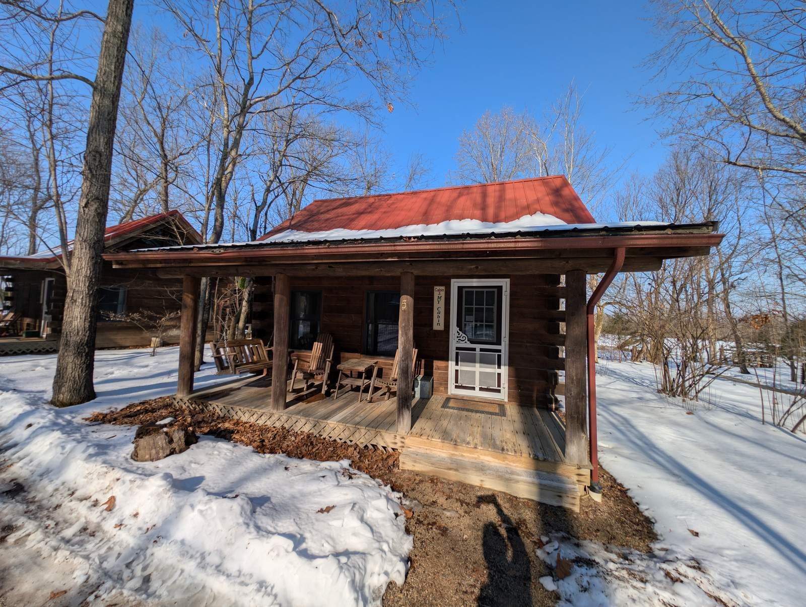 A red-roofed log cabin exterior in snow