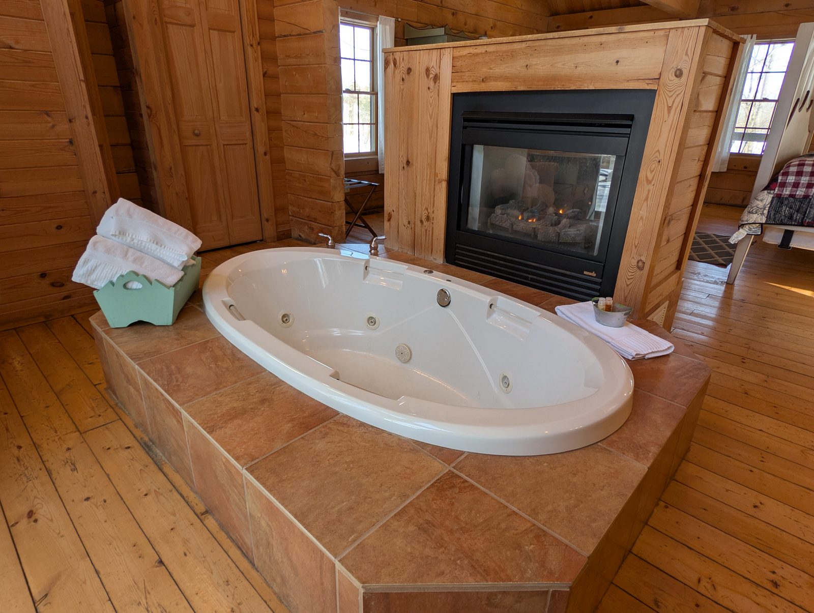 A whirlpool tub set beside a gas fireplace in a cabin