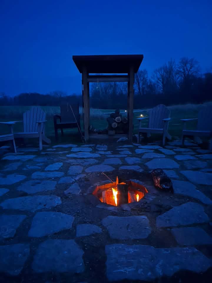 The fire ring lit at dusk on the Murphin Ridge lawn