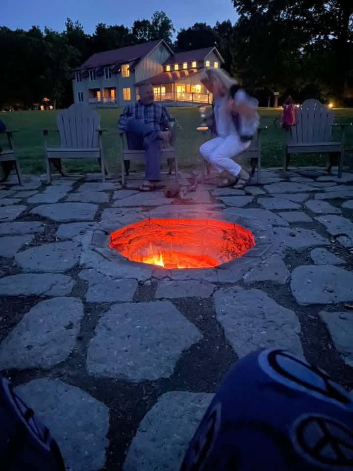 Guests gathered around the fire ring at dusk
