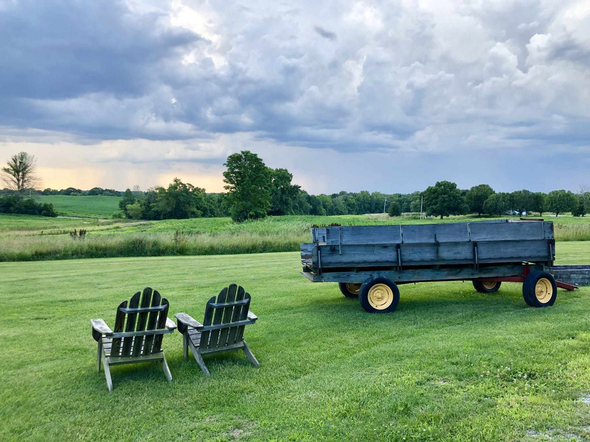 Adirondack chairs on the lawn under a wide evening sky